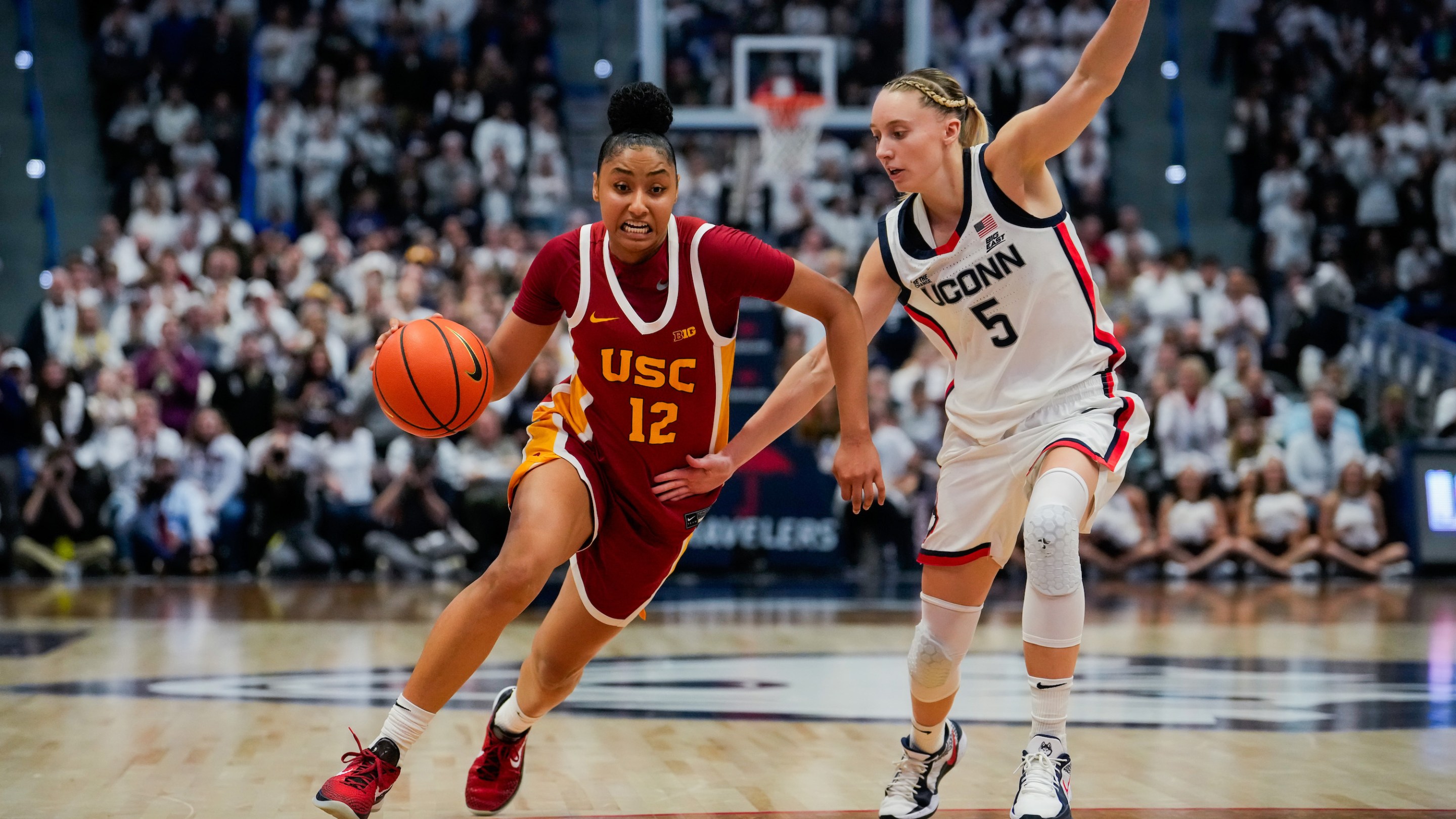 JuJu Watkins #12 of the USC Trojans is defended by Paige Bueckers #5 of the Connecticut Huskies during the second half of an NCAA women's basketball game at the XL Center on December 21, 2024 in Hartford, Connecticut.
