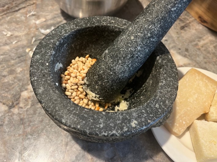 Ground garlic and toasted pine nuts, in a mortar.